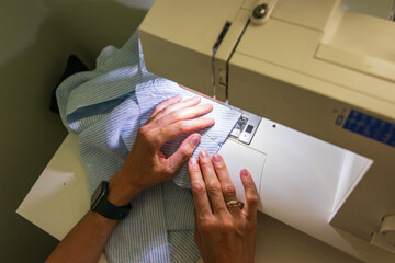 A woman sewing at home. Creating own clothes.