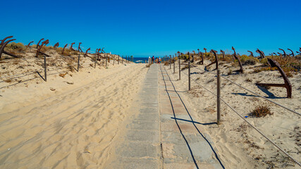 Exhibition of anchors in the dune at the access to Barril beach, belonging to the Pedras del Rei village, Tavira, Algarve, Portugal.