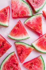 Fresh watermelon slices on pastel pink background, minimal summer fruit concept
