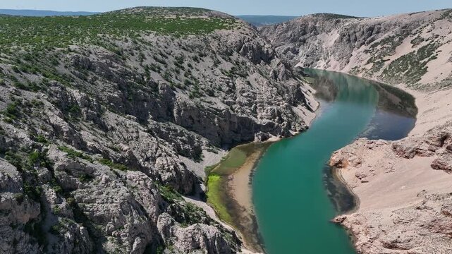 Zrmanja canyon river from Obrovac to river mouth aerial. Aerial shots of winding Zrmanja river cutting through deep canyon, lush spring colors and remote paths