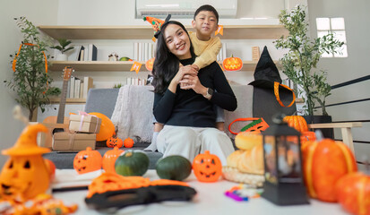 Halloween Celebration. A joyful mother and son enjoying festive decorations and activities at home.