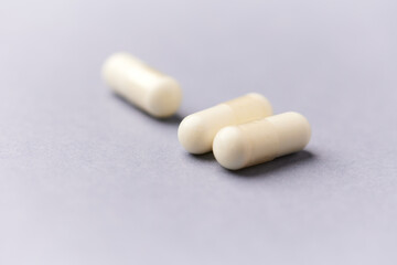 Amino acids capsules on bright background. Soft focus. Close up. Copy space.	