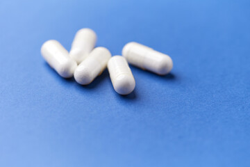 Creatine capsules on paper background. Soft focus. Close up. Copy space.