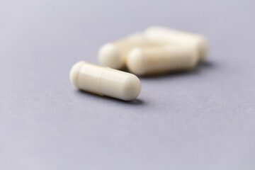 Creatine capsules on paper background. Soft focus. Close up. Copy space.