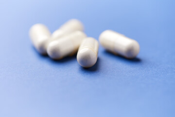 Creatine capsules on paper background. Soft focus. Close up. Copy space.