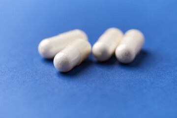 Creatine capsules on paper background. Soft focus. Close up. Copy space.