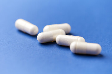 Creatine capsules on paper background. Soft focus. Close up. Copy space.