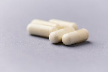 Creatine capsules on paper background. Soft focus. Close up. Copy space.
