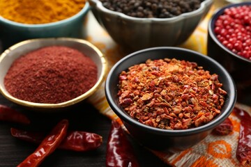 Different aromatic spices on wooden table, closeup