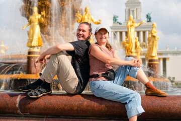 Delighted travelers sharing a romantic moment by the beautiful Friendship of Nations Fountain in...