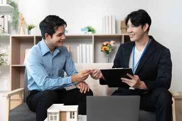Real Estate Meeting. Professionals exchanging ideas over property plans with a model house.