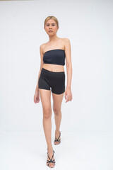 A bold young Asian woman striding toward the camera with confidence and attitude on her face....