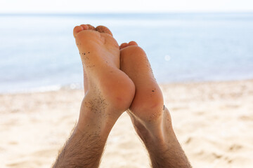 Feet of a resting guy against the  sea