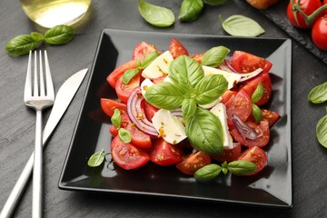 Tasty salad Caprese served on black table, closeup