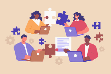Diverse team collaborating on a project using laptops and puzzle pieces
