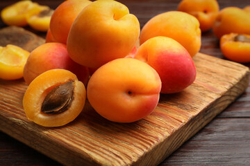 Many fresh apricots on wooden table, closeup