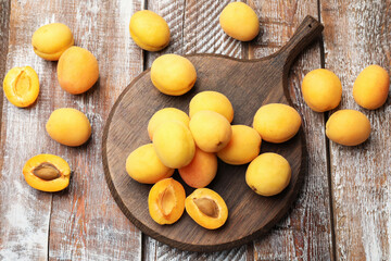 Fresh ripe apricots on wooden table, flat lay