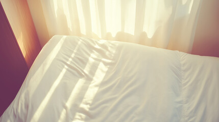 Soft sunlight filtering through gossamer curtains, illuminating rumpled white bedding with gentle, peaceful radiance