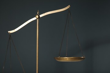Scales of justice on gray background, closeup