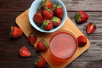 Tasty compot and strawberries on wooden table, flat lay