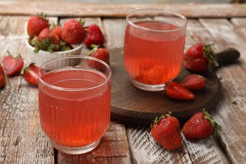 Tasty compot and strawberries on wooden table, closeup