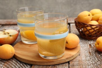 Tasty compot and fruits on wooden table, closeup