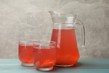 Tasty compot in glasses and jug on light blue wooden table