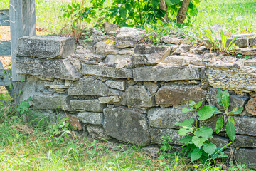 Ancient stone structure, part of rural fencewall, weathered, lichen, moisture, overcast day, earth...