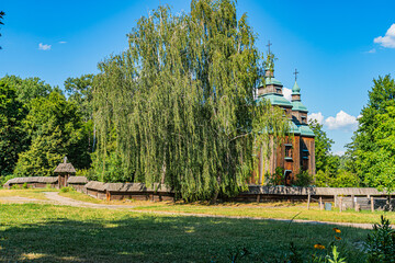 Ancient Central European village, old building with green roof, surrounded by lush greenery, clear...