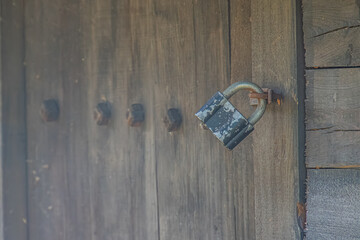 Weathered wooden door with metal latch, in an ancient Central European outdoor setting, muted colors brown, blue-green, natural light from upper right