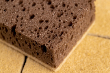 glued and tightly intertwined synthetic sand-colored threads on a sponge that is used for cleaning and washing, close up