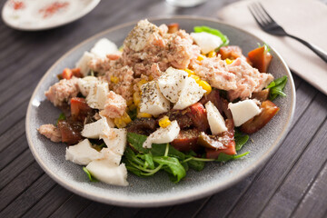 Fish salad with canned tuna and corn, tomatoes and arugula