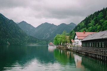 Fototapeta premium Lakeside village nestled beside a serene lake, with mountains in the background