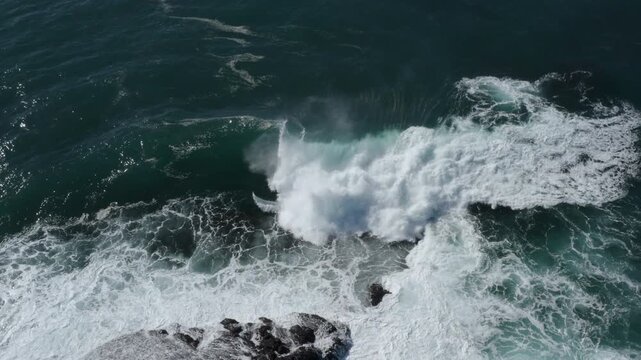 A large ocean wave curls and breaks over an exposed reef. Captured from high above during a storm swell on the East Coast of Australia.