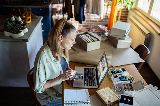 Young woman working on online boutique small business from home office