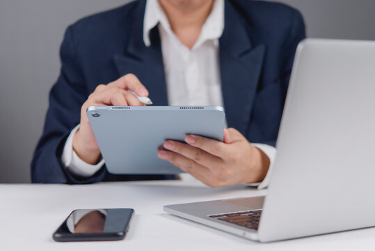 businessman holding a tablet and stylus pen, modern office work, creative design, and the use of technology to enhance productivity and professional workflow.