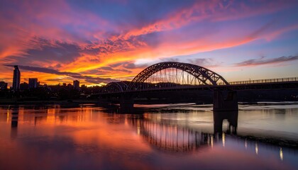 Naklejka premium Arched Bridge Silhouette Under Fiery Sunset Sky