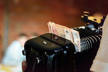 Serbian dinars in accordion, custom of tipping the musicians when celebrating