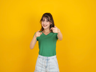 Fototapeta premium Woman pointing camera, photo of excited happy cheerful young caucasian woman pointing camera congrats, say you got this. Inviting to event concept isolated on yellow background, copy space.