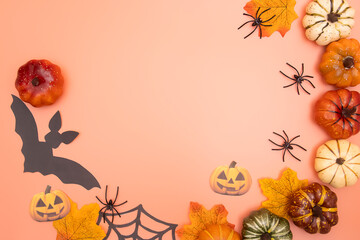 The Halloween apartment lay on a bright orange background: Pumpkins, black bats, and spiders are...