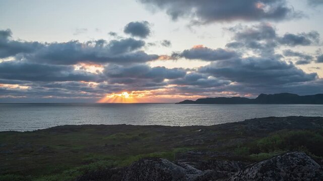The coast of the Barents Sea near the village of Teriberka in the evening on polar day. The sun moves parallel to the horizon line Polar day on arctic summer from sunset to dawn