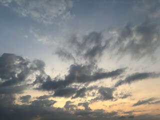 Dramatic sky at sunset with beautiful orange, blue, and grey clouds. A perfect natural background