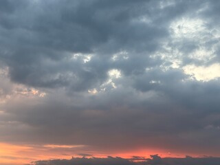 Dramatic sky at sunset with beautiful orange, blue, and grey clouds. A perfect natural background