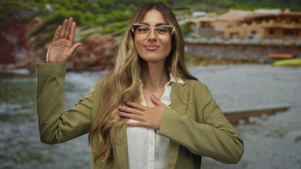 Woman lifts arms with smiling expression revealing open gesture at sandy beach; confidence optimism...