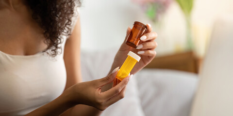 Medication Management. A woman examining her prescription bottles at home.