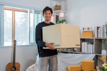 Moving Day. Young man carrying large box in bright living room.