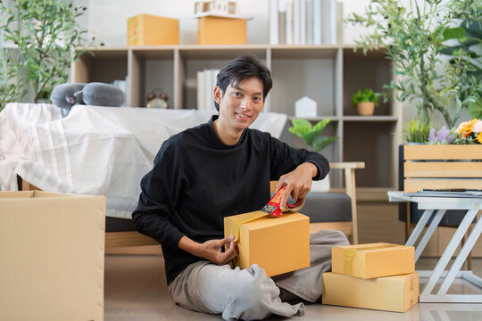Unboxing. Young man excitedly opening delivery boxes at home.