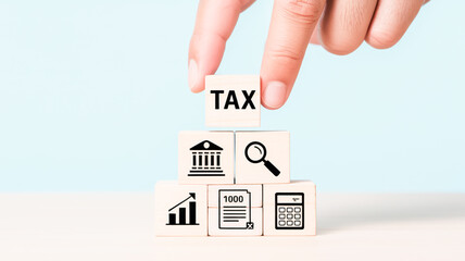 A professional business concept image featuring wooden blocks with financial and tax-related icons arranged in a pyramid structure on a light blue background.