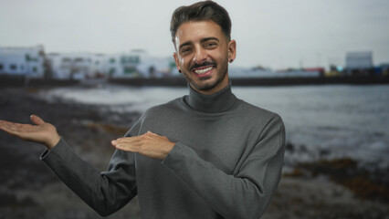 Casual young hispanic man holds open palms in front of building with a genuine smile and relaxed...