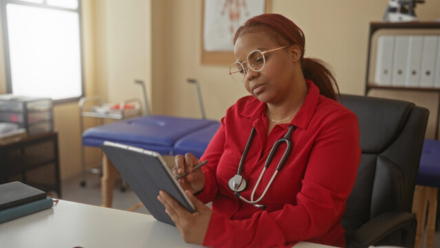 Woman doctor wearing stethoscope writes patient notes on tablet with stylus in office; expertise care focus.